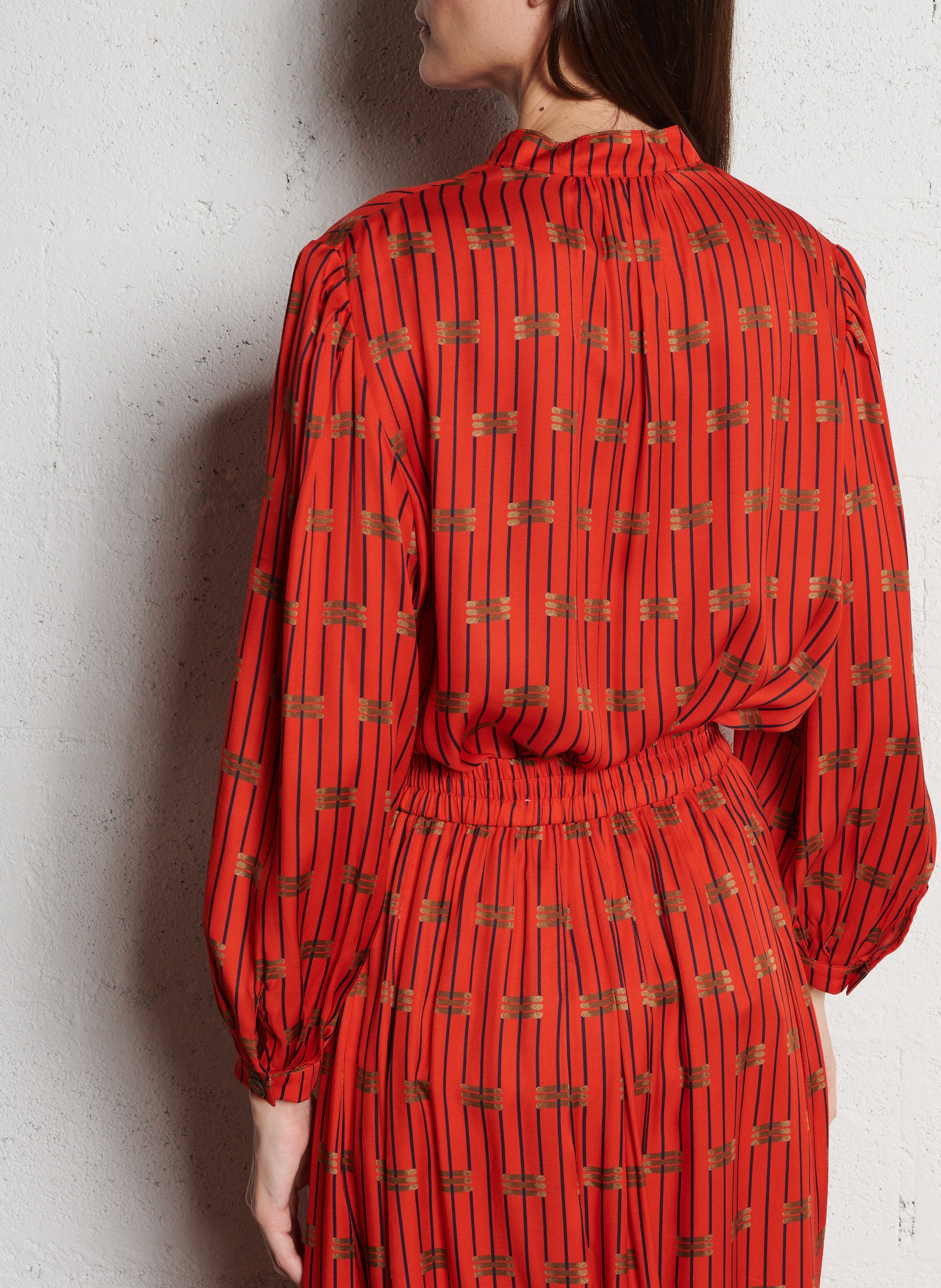 - Ronde hals
- Ruime pasvorm
- Lange mouwen
- Manchetten met knopen
- Knoopsluiting aan de voorkant
- Soepelvallende stof
- Print SUZIE WINKLE Rood