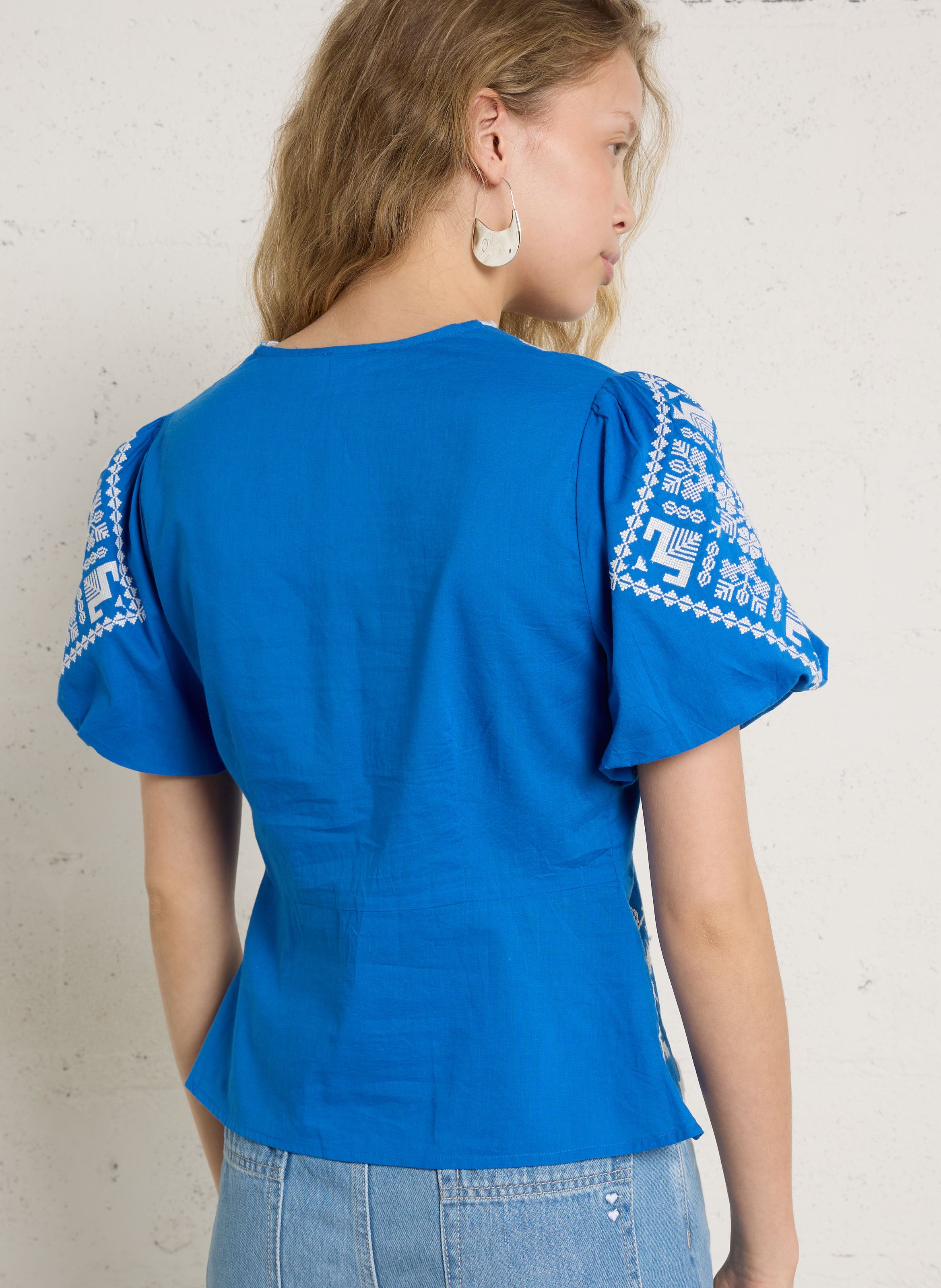 Top mit V-Ausschnitt und bestickten Knöpfen. Blau